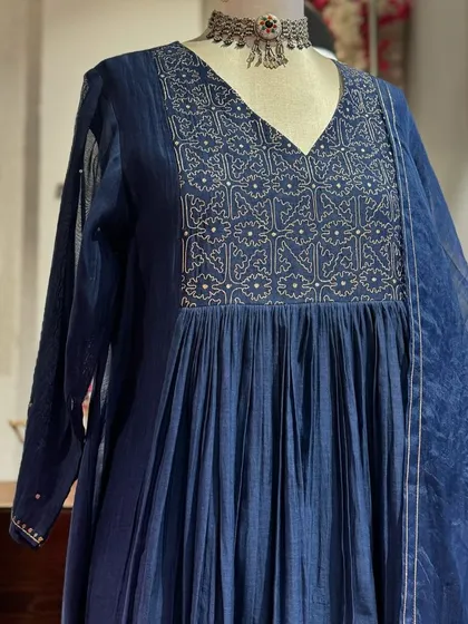 A detailed view of the navy blue anarkali, showcasing the intricate silver embroidery on the yoke and the sheer, lightweight dupatta.