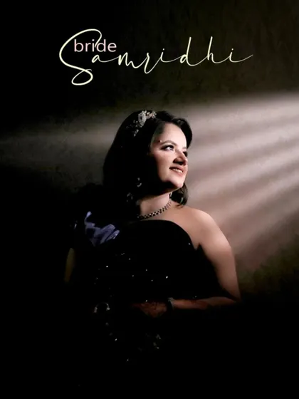 A dramatic portrait of bride Samridhi, with a single beam of light illuminating her, creating a cinematic and mysterious feel.