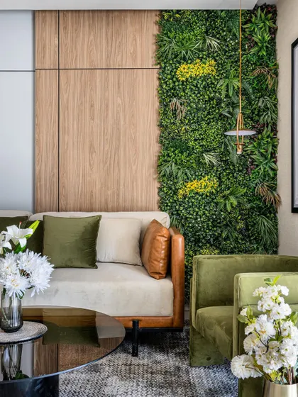 To bring nature indoors, we designed a living green wall as a stunning feature in this living room. Paired with wood paneling and earthy green furniture, it creates a fresh, vibrant atmosphere that is both calming and visually striking.