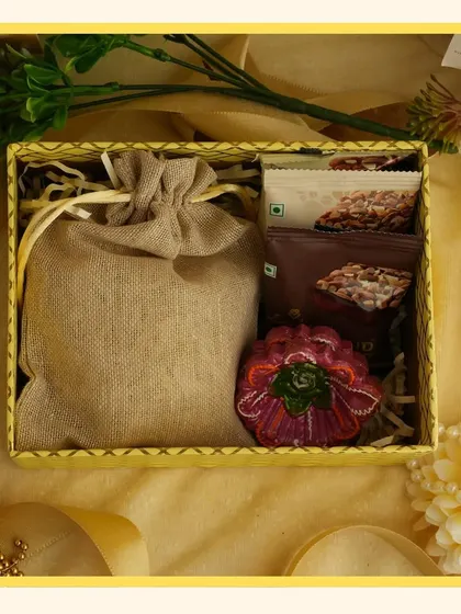 A cheerful yellow-themed hamper for Navratri or Diwali. This gift includes a jute potli bag and a decorative diya, combining rustic charm with festive brightness.