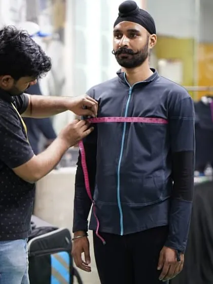 Precision extends to the gear. Here, an athlete gets his shooting jacket custom fitted at our club, ensuring optimal comfort and stability.