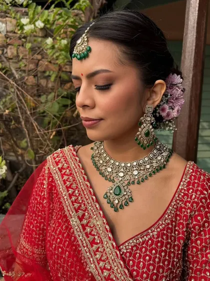A side profile of the bride, showcasing the soft smokey eyes and the beautiful floral hair accessory. This highlights how every detail, from makeup to hair, comes together to create a cohesive bridal look.