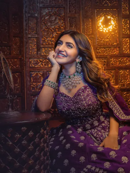 A candid, smiling shot of Sreeleela. This image captures the beauty of the complete look, from the flowing hair to the detailed embroidery of the couture lehenga, in a moment of genuine joy.