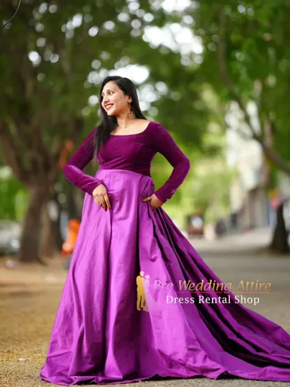 A smiling shot in the purple velvet and satin gown, showing its elegant movement.