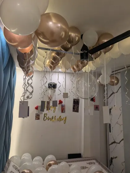 A close-up of the ceiling decor, with chrome balloons and personal photos hanging from ribbons.