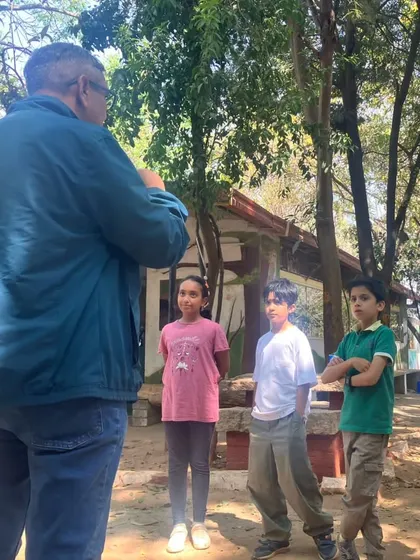 A group of children engage in a serious discussion with a wildlife expert at the sanctuary. These conversations are crucial for building a deeper understanding of conservation issues.