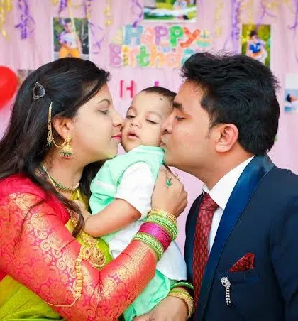 Parents give their baby a kiss on each cheek in a touching family moment. These are the priceless memories we preserve for you.