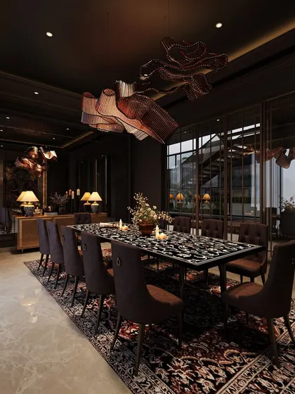 A view of the moody dining room, showing its connection to an outdoor space through large glass windows. This provides a contrast between the dark interior and the light-filled exterior.