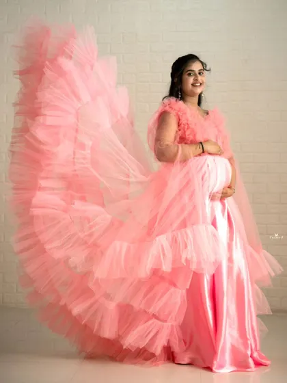 This side view highlights the incredible volume and texture of the pink ruffled trail, showing why it's a favorite for creating dramatic maternity portraits.