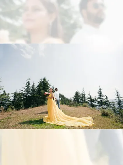 A wide shot of a bride in a flowing yellow gown, standing on a hilltop. The long train of the dress and the mountain landscape create a dramatic and beautiful image.