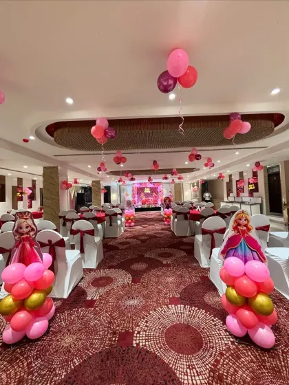 We can transform any banquet hall into a princess ballroom. This image shows the full room setup with themed aisle markers and coordinated chair sashes.