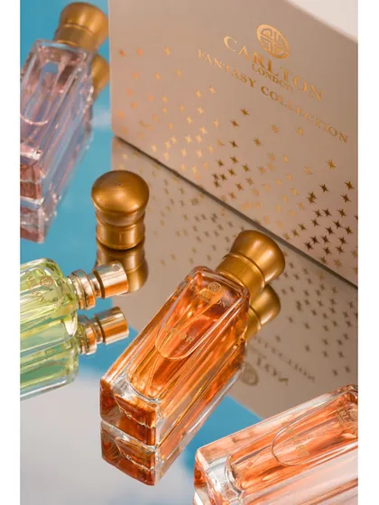 This shot uses a mirror to create interesting angles and reflections of perfume bottles next to their packaging. The composition is dynamic and sophisticated, highlighting the product's luxurious design from multiple viewpoints.