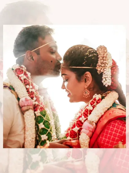 A soft and romantic close-up of the groom kissing the bride's forehead, a timeless and emotional wedding photograph.