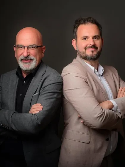 A classic back-to-back pose for a duo of corporate leaders. This composition is great for showcasing partnership and a strong working relationship.