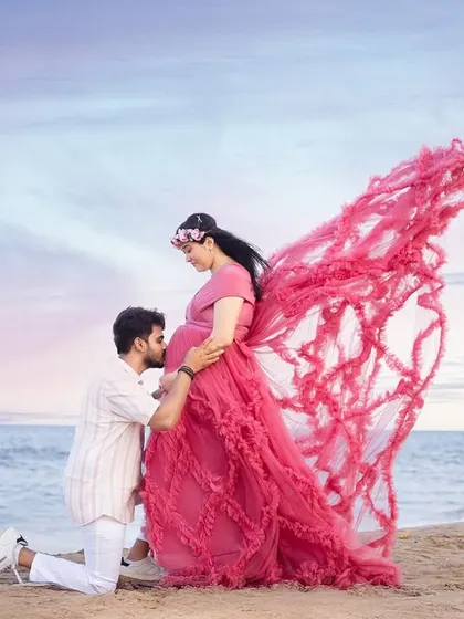 A beautiful video showcasing a couple's beach maternity shoot, complete with a flowing pink gown and artistic butterfly wing effects.