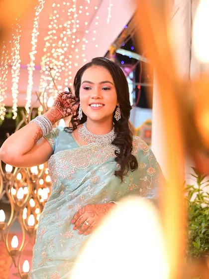 A creative shot through the decor, capturing her happy expression and sparkling jewelry.
