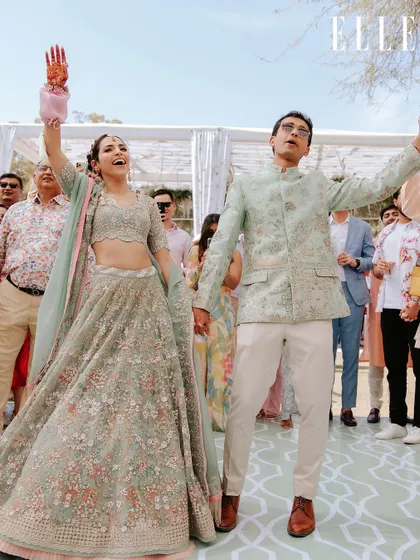 A candid moment of celebration from Amala and Aditya's musical welcome lunch, featured in ELLE India. Their joy is palpable as they dance among their guests.