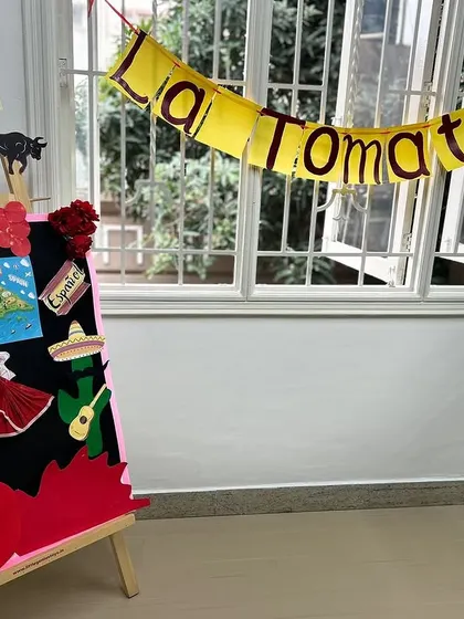 Our 'La Tomatina' display board, featuring symbols of Spanish culture like flamenco fans, a guitar, and a soccer ball. This serves as a visual anchor for our thematic learning.