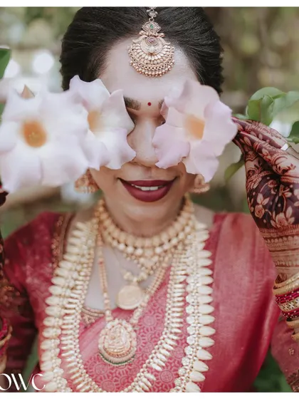 A playful and creative portrait with the bride covering her eyes with flowers.