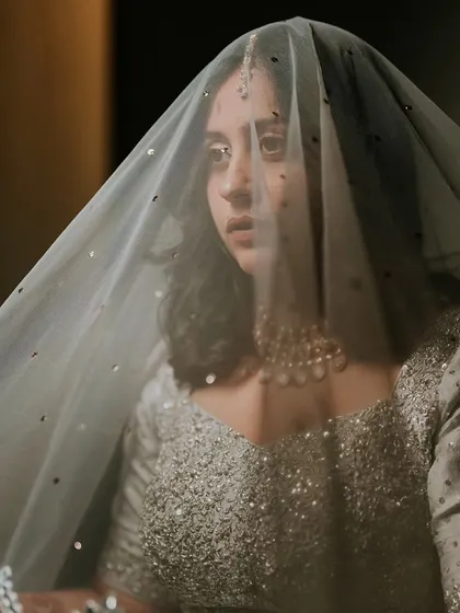 A beautiful, pensive portrait of the bride under her veil, capturing a moment of quiet reflection before the ceremony.