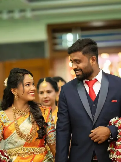 A candid shot of Akshitha and her husband at their reception. Her makeup is natural and radiant, letting her joyful expression be the main focus.
