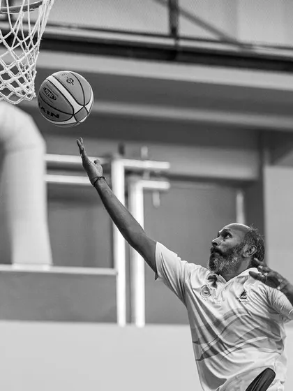 A powerful black and white shot of our lead basketball coach, Capt. Prasad, demonstrating a layup during the High Performance Camp.