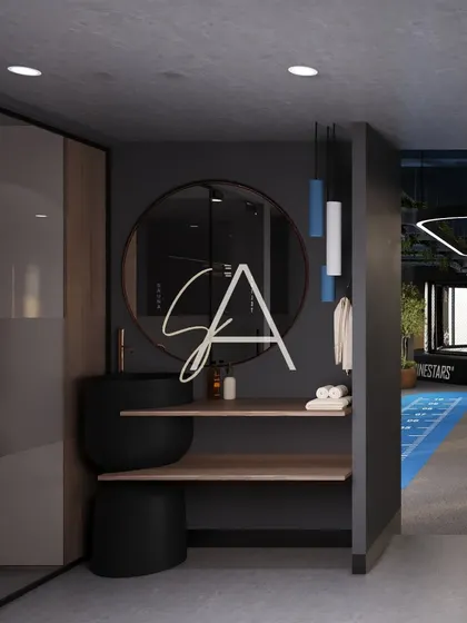 The vanity and changing area adjacent to the gym floor. A large round mirror, sleek black basin, and modern pendant lights provide a stylish and functional space for members to freshen up.