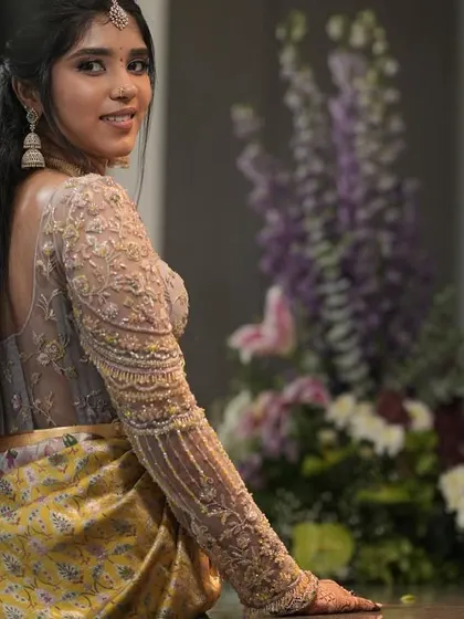 A beautiful side profile of the client, showcasing the stunning embroidery on her full-sleeved blouse.