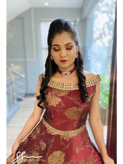 A serene pose showing the beautiful blend of red and gold eyeshadow. This warm, shimmery eye makeup is a fantastic choice for the festive atmosphere of a Sangeet night.