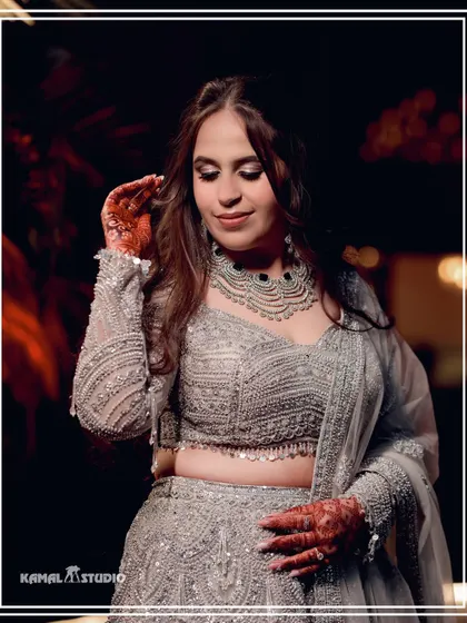 A close-up portrait of the bride, highlighting the intricate beadwork of her lehenga and her elegant jewelry.