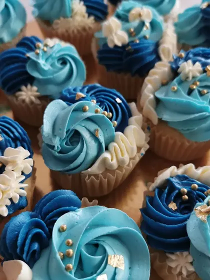 I just love playing with colors. These cupcakes are decorated with shades of blue buttercream, piped into elegant rosettes and swirls. I added some tiny white flowers, gold sprinkles, and a bit of gold leaf to make them extra special.