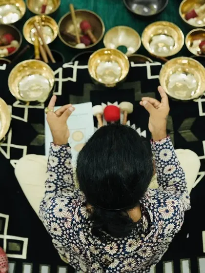 An overhead view of a student surrounded by a set of chakra-tuned singing bowls.