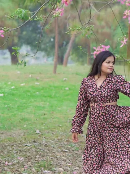 A candid photo of the woman enjoying the moment, framed by pink blossoms during her pre-wedding outdoor shoot.