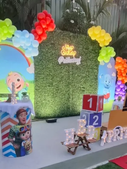 A detailed shot of the Cocomelon birthday setup, focusing on the custom-wrapped pedestals and colorful block props.