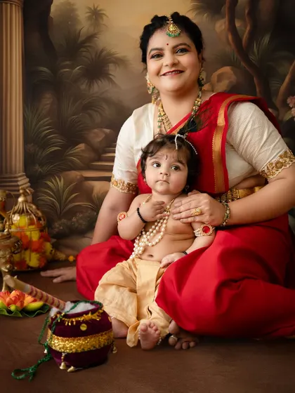 A beautiful family portrait for Janmashtami, with the baby dressed as Krishna and surrounded by traditional props.