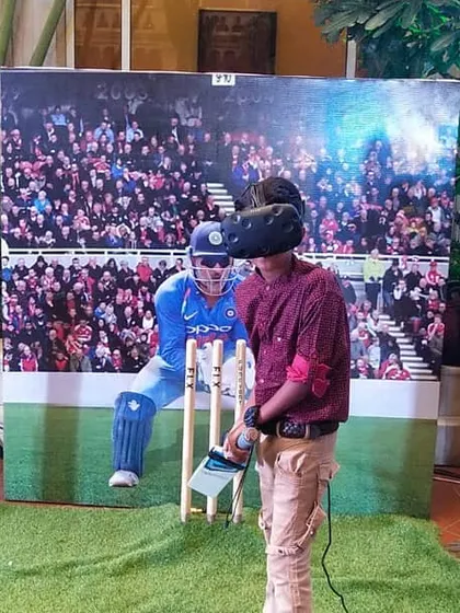 A guest enjoys our VR cricket experience at an event for ICICI Bank. The setup includes a physical pitch, a large screen for spectators, and professional audio, creating an immersive atmosphere for both the player and the audience.