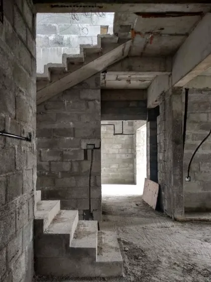 An in-progress shot of a concrete staircase at a residence in Uttarahalli. This image shows the underlying structure, combining a folded plate design with a waist slab for strength and form.