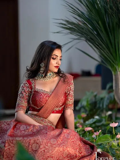 A different angle of this modern red lehenga look, showing the soft waves in her hair and the beautiful fit of the outfit.