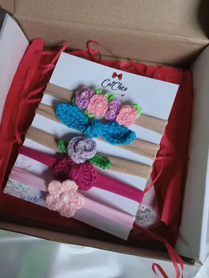 Our floral newborn headband set, packaged beautifully in a gift box with red shredded paper.