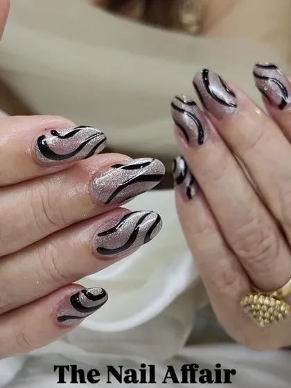 A unique design with black swirls over a textured, glittery base. The pattern gives a sophisticated, modern feel to the nails.