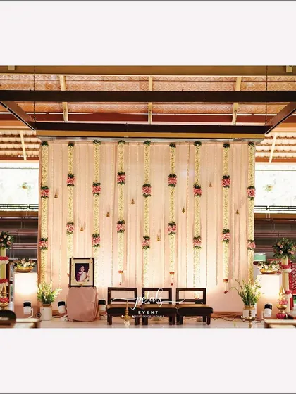A wider view of the ritual space, with its elegant backdrop of fabric and floral streamers.