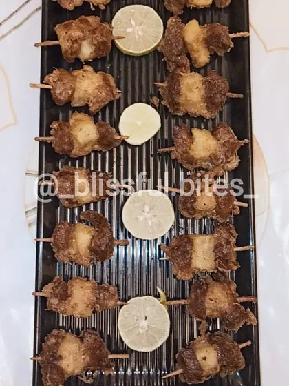 The cooked Kaadi Gosh skewers, fried to perfection and served with fresh lemon wedges. These tender beef appetizers are juicy and full of flavour.