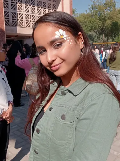A single white daisy with a gold center and a sprinkle of glitter, placed as a beautiful accent on the forehead.