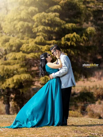 A sun-flared shot of a couple embracing in a forest clearing, highlighting the warmth and romance of their mountain pre-wedding session.