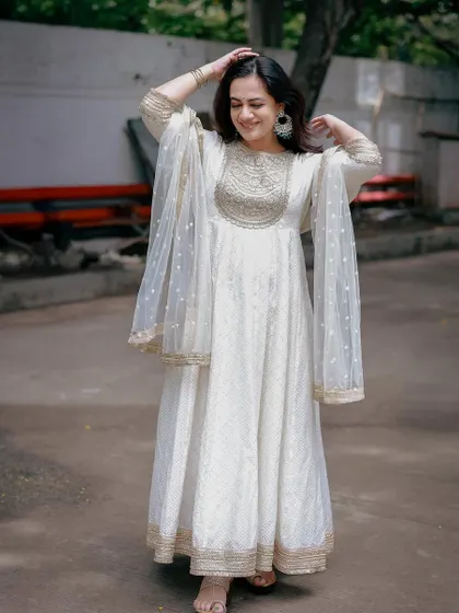 A full-length shot of the white Anarkali, showing its flowy silhouette and the delicate sheer dupatta.