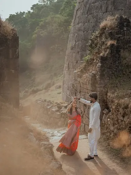 A couple dancing amidst the ruins of an old fort. The dusty, golden light adds a touch of magic and history to this romantic pre-wedding moment.