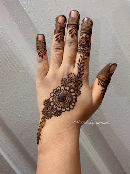 A simple and elegant Arabic-inspired motif on the back of the hand. This kind of small, standalone design is perfect for a party or for guests at a wedding.