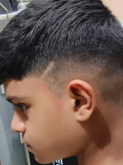 A sharp fade with a line design, adding a bit of edge to this young man's haircut.