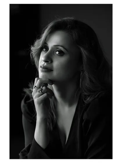 A classic black and white portrait with dramatic lighting. The model's expression is intense and captivating.