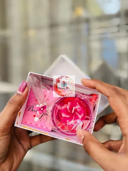 A small, sweet Valentine's gift box holding a rose-shaped soap or candle, presented with a "Be Mine" card.